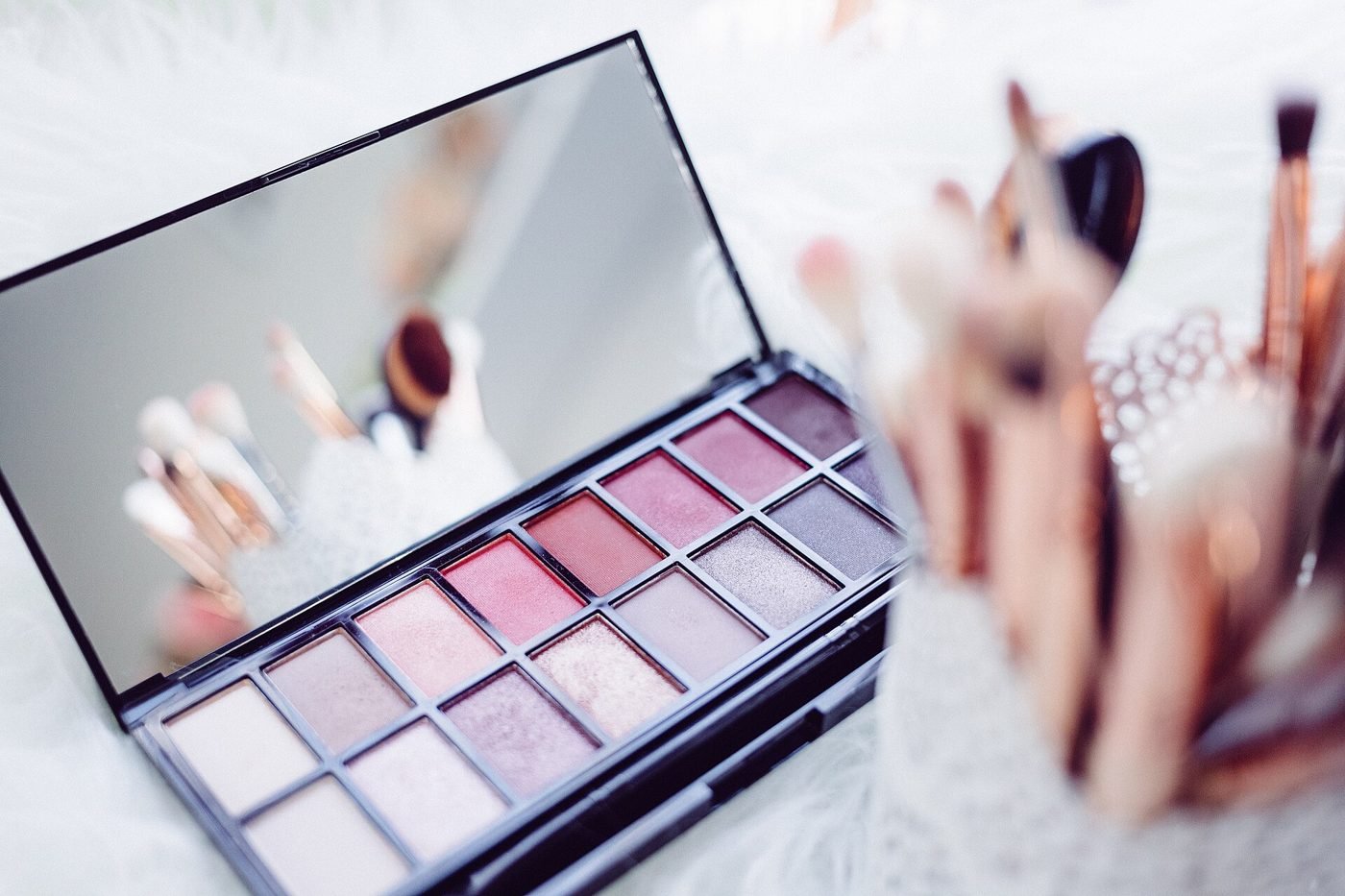 An eyeshadow palette with makeup brushes